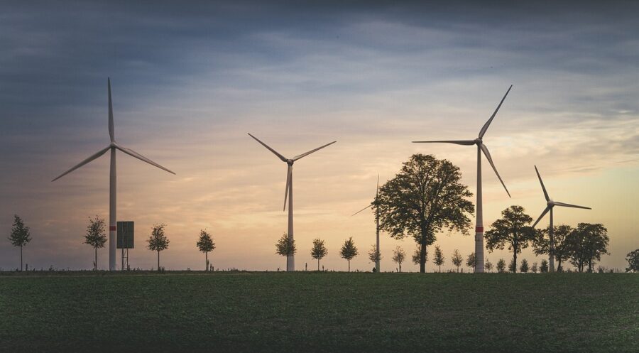 Wind turbine near a tree line at dusk