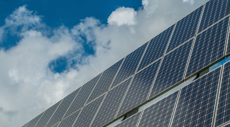 Solar panels under a blue sky with clouds