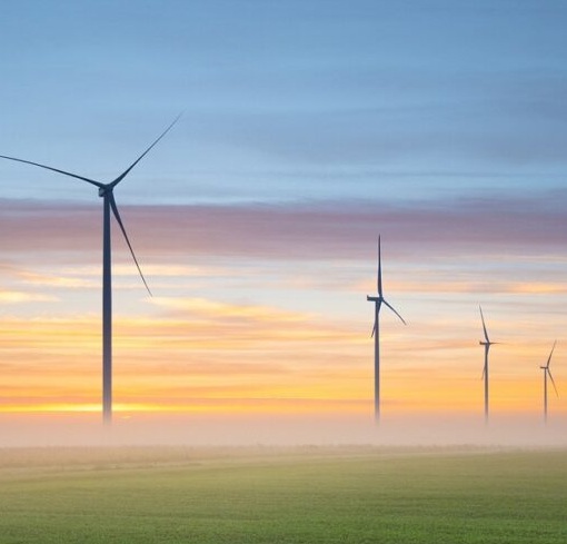 Wind turbines on farmland at sunrise